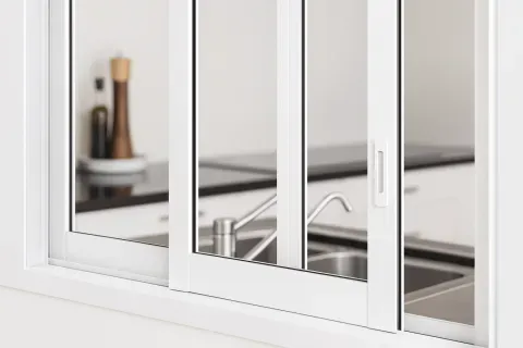 Ventana corredera de aluminio blanca instalada sobre encimera de cocina en Barcelona