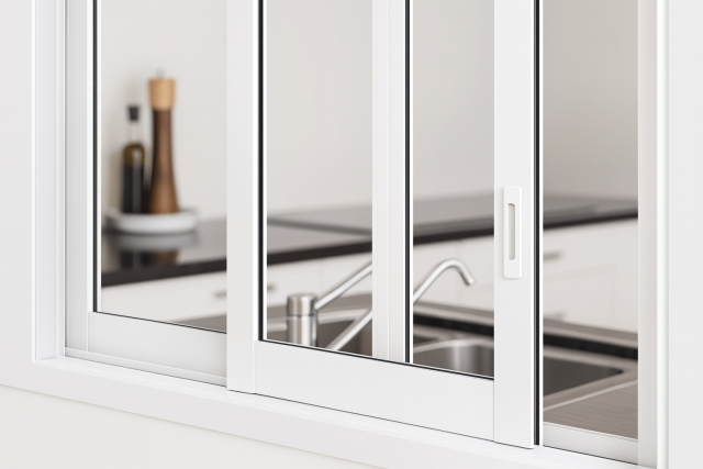 Ventana corredera de aluminio blanca instalada sobre encimera de cocina en Barcelona